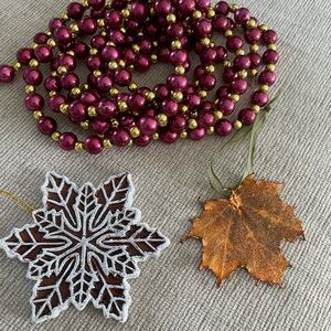 Garland. One metal delicate leaf ornament and a ceramic snowflake